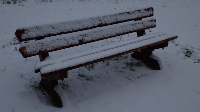 在一个被雪覆盖的公园长椅上。
