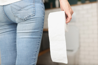女人手里拿着卫生纸卷，来到卫生间