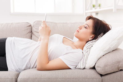 体贴的女孩在沙发上发手机短信