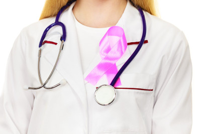 医生用粉红色的癌症丝带aids标志在胸部
