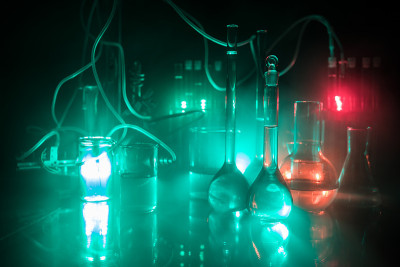 药学和化学主题。在研究实验室用溶液测试玻璃烧瓶。科学和医学背景。深色背景上的实验室试管