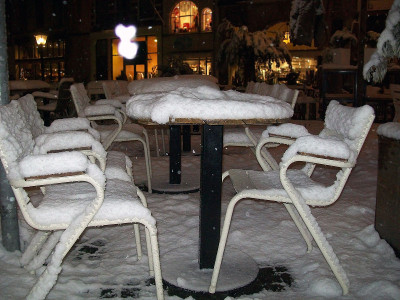 在冬季，户外餐厅餐桌被雪覆盖