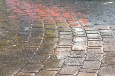 几滴大雨落在人行道上。