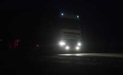 卡车在黑暗中沿着夜间的道路行驶。