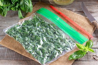 塑料袋里的冷冻香草(罗勒)。冷冻蔬菜。冷冻食品的概念