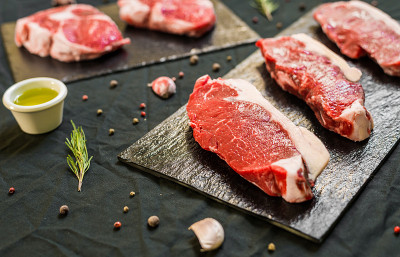 牛肉牛排肉与香料和香草在黑色背景下