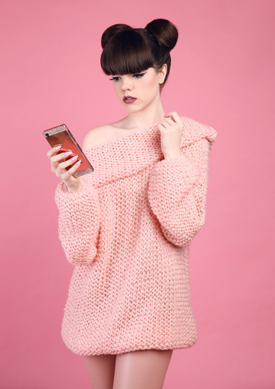 黑发女人拿着手机。时尚工作室青少年看起来风格