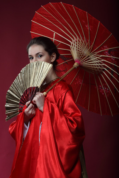 穿着和服的女孩拿着伞玩得很开心