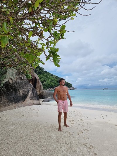 泰国普吉岛的斯Similan海滩，年轻人在沙滩上散步在游泳短
