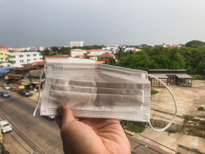 手持一次性卫生口罩。保护自己免受COVID-19病毒的侵害。