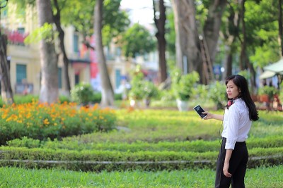 一名年轻女子在河内用智能手机听音乐
