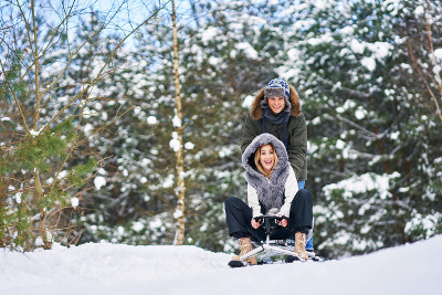 一对夫妇在冬天的雪地上玩雪橇
