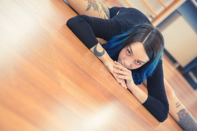 蓝色头发的纹身女人在健身房跳钢管舞