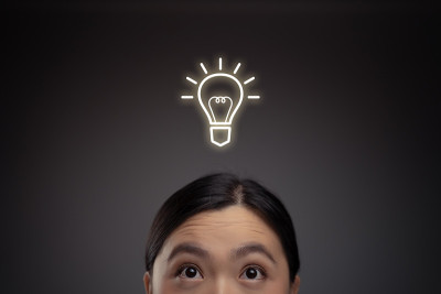 快乐的亚洲女人和灯泡图标全息图效果。