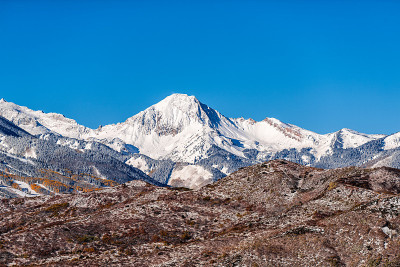 白杨，科罗拉多州与白色岩石山雪峰和黄色的秋天树叶在咆哮的叉山谷在冬天