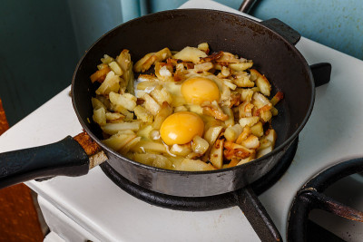用煎锅煎土豆和鸡蛋，食物单身汉
