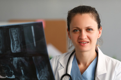 Doctor neurologist holds in hand an x ray of spine
