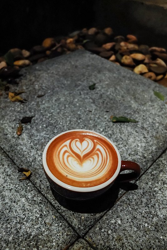 地板上有拿铁艺术的咖啡杯