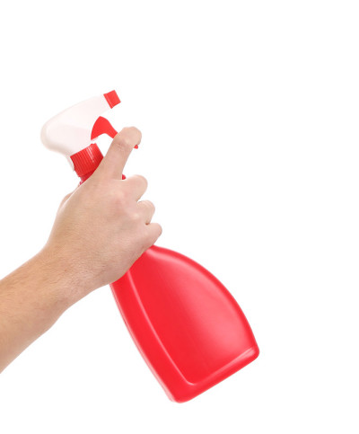 手里拿着红色塑料喷雾器。