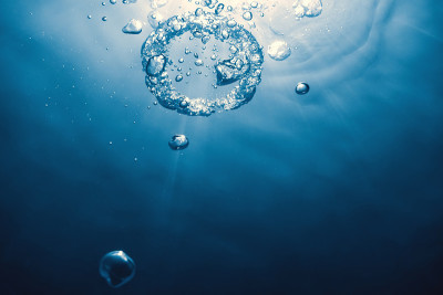水下的气泡环向太阳升起。