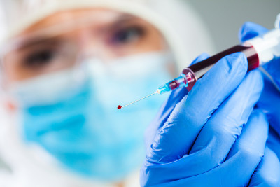 医生或实验室科学家穿着个人防护装备，手持装满PRP血浆的注射器