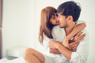 一对幸福的年轻夫妇在家里的卧室里放松。