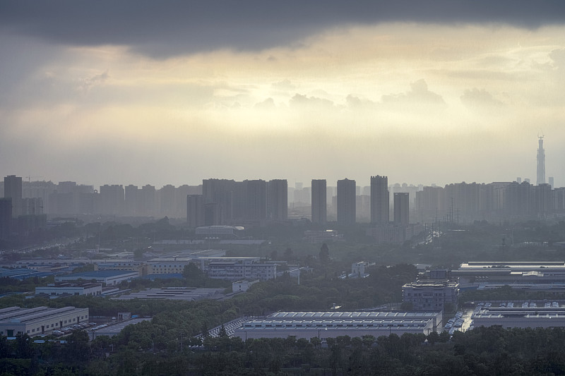 太阳在雨中穿过云层形成潮汐效应的城市
