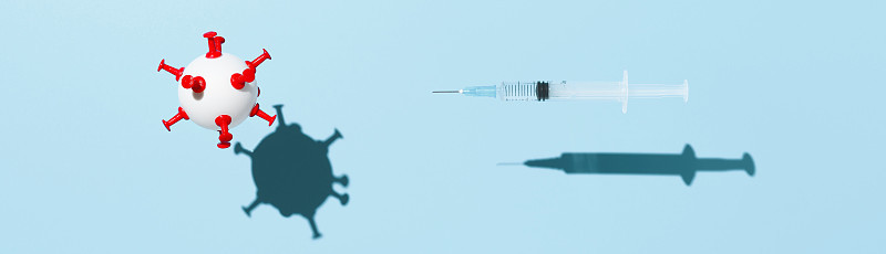 冠状病毒疫苗接种的概念。一个装有COVID-19疫苗的医疗注射器和一个悬浮在淡蓝色背景上的病毒状白球