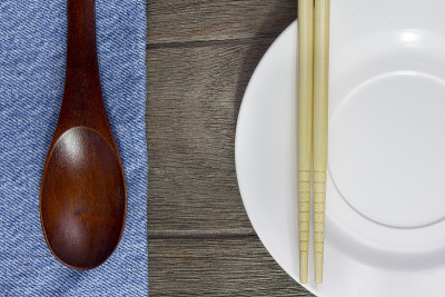 木头背景板，筷子和勺子上的蓝色牛仔裤文字