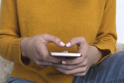 女人在家里用智能手机发短信的特写