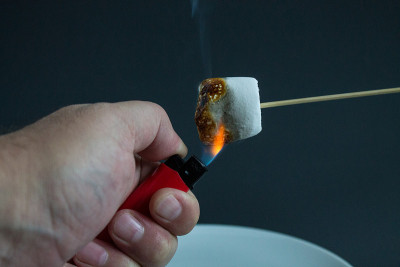 用打火机在木棍上炸一个白色棉花糖