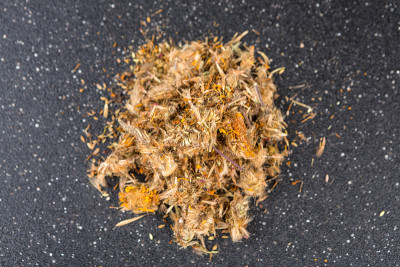 黑色背景上一堆晒干的山金车树叶