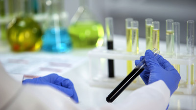 生物研究人员观察黑色液体管，石油生产工业