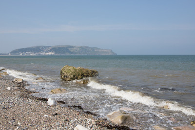 海浪拍打着小奥姆的岩石，Llandudno。北威尔士卵石滩