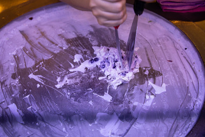 女人在圆形冷盘上手工制作冰淇淋