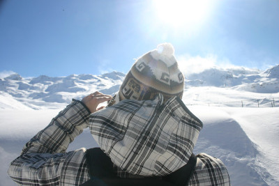 穿着冬季夹克的人看着远处的雪山