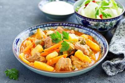 炖牛肉与蕃茄酱在平底锅，在木背景。azu。