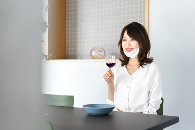 年轻女子戴着面具喝酒