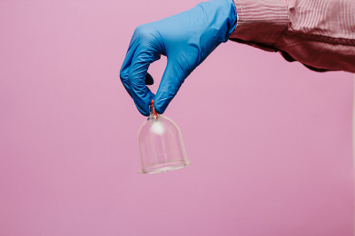 真空泵和罐的hijama。武器。在粉红色的背景上
