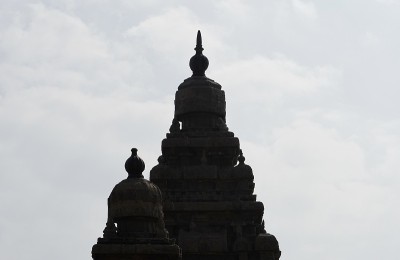 在清澈的天空背景下，有雕刻的古代岸边寺庙。泰米尔纳德邦马哈巴利普兰海岸寺庙的历史遗址。印度建筑岩石艺