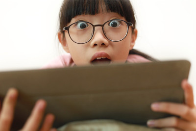 一个年轻的亚洲女孩在家里用平板电脑