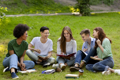 学习的概念。一群大学朋友在户外准备课程，一起学习