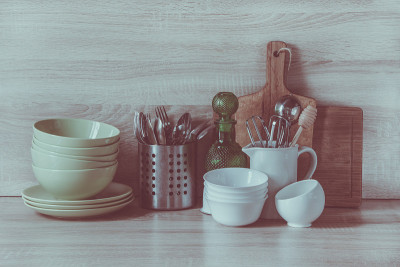 厨房静物作为设计背景。桌上有陶器、餐具。