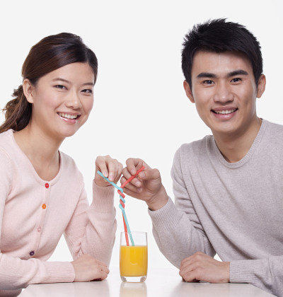 一对年轻夫妇分享一杯橙汁，拍摄