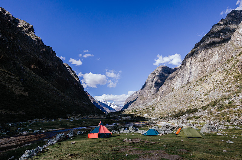 在秘鲁圣克鲁斯的奎布拉达徒步旅行中，在雪山背景下的大羊驼营地里的帐篷