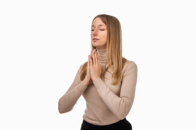 迷人的金发女孩祈祷家人健康，双手合十祈祷