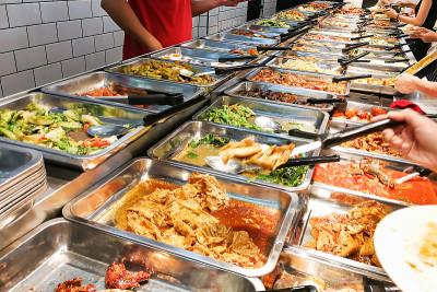 人们在马来西亚的中国经济大米摊上挑选食物