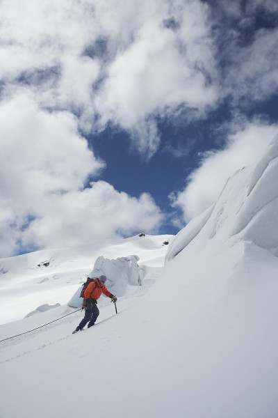 徒步旅行者上雪山斜坡