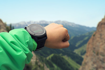 登山者在山顶检查运动手表上的高度计