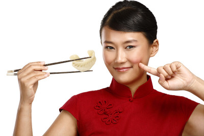 一位中国妇女用筷子展示亚洲食物